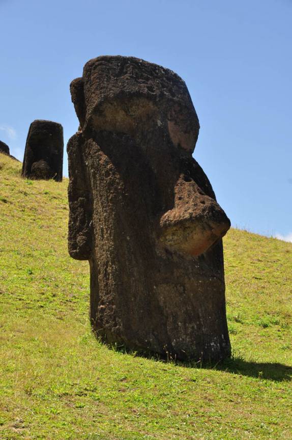Antigos Moais em Rano Raraku, a fábrica de Moais, parcialmente cobertos pelo tempo. Ainda estavam a venda quando a civilização se perdeu (em Rapa Nui (ou Ilha de Páscoa), território chileno no meio do Oceano Pacífico)